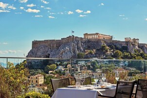 A table set for dining with a view of a historic fortification on a hill.