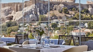 A table set for dining with a view of ancient ruins in the background.