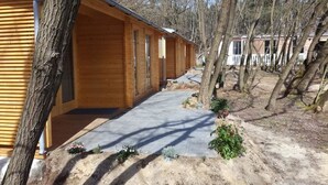 Un hilera de cabañas de madera con un sendero de concreto que lleva a la entrada.