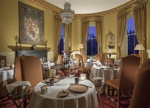 A formal dining room with multiple tables set for a meal, elegant chairs, and a chandelier. - Crossbasket Castle Hotel & Restaurant (Glasgow)
