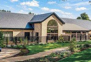 A modern building with a brick facade, large windows, and a sloped roof. - Crossbasket Castle Hotel & Restaurant (Glasgow)