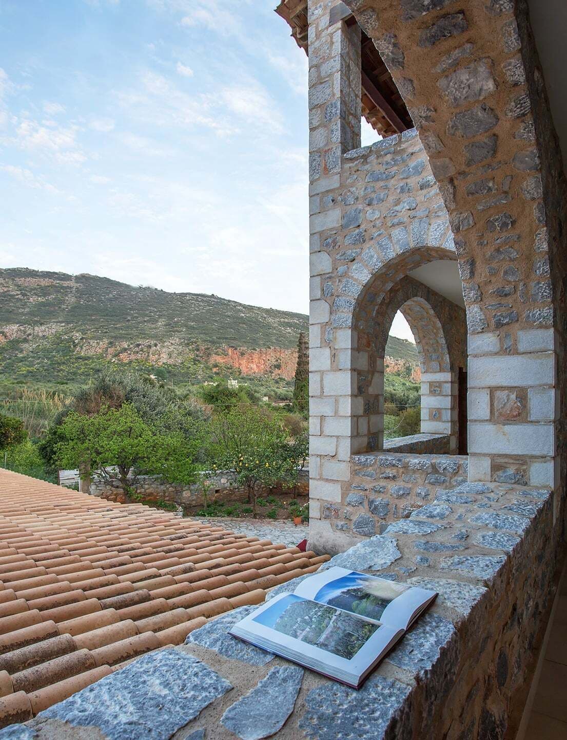 A stone archway leading to a terrace with a book on it.