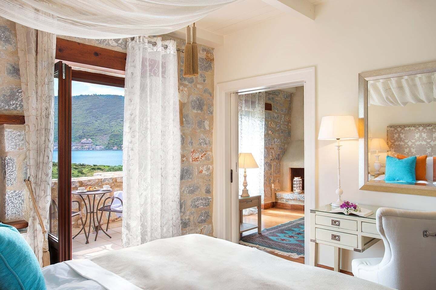 Une chambre à coucher avec un lit, une table de chevet, une lampe et une vue sur un plan d’eau.
