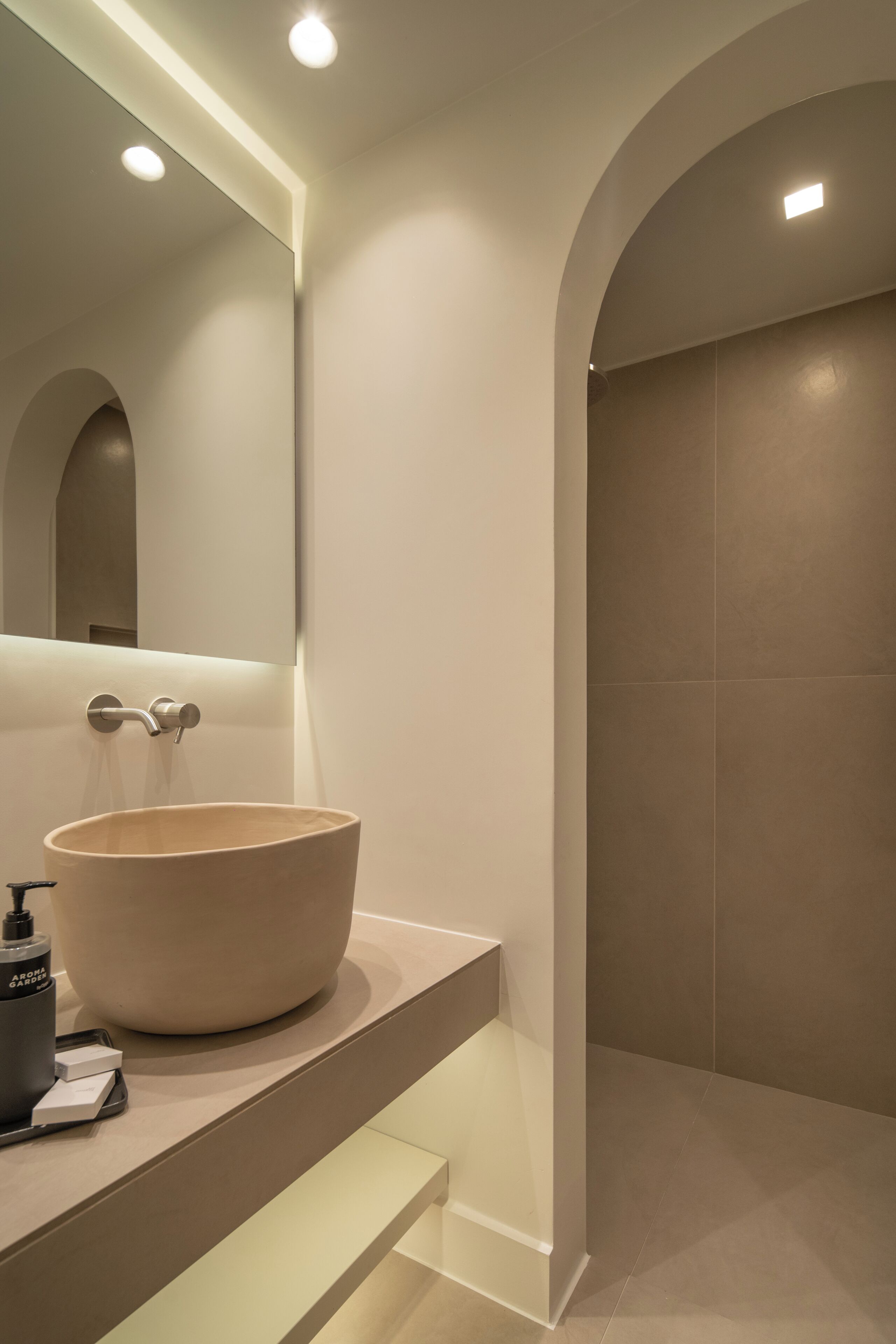 A modern bathroom with a large vessel sink, a mirror, and recessed lighting.