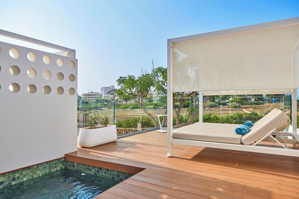 A modern outdoor pool area with a lounge chair and a view of the surrounding landscape.