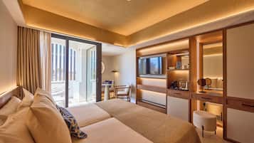 Habitación de hotel con una cama grande, un televisor, un escritorio con una silla y un ventanal corredero al balcón.