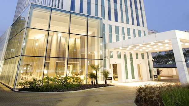 Um edifício moderno de vários andares com fachada de vidro e padrões geométricos iluminados.