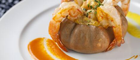 A lobster tail served on a white plate with a sauce.