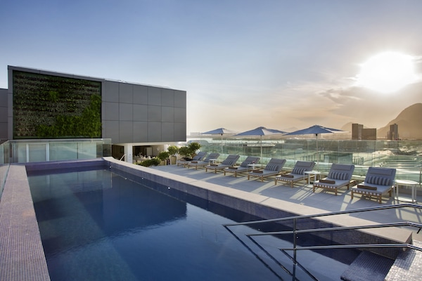 Een buitenzwembad, parasols bij het zwembad en ligstoelen