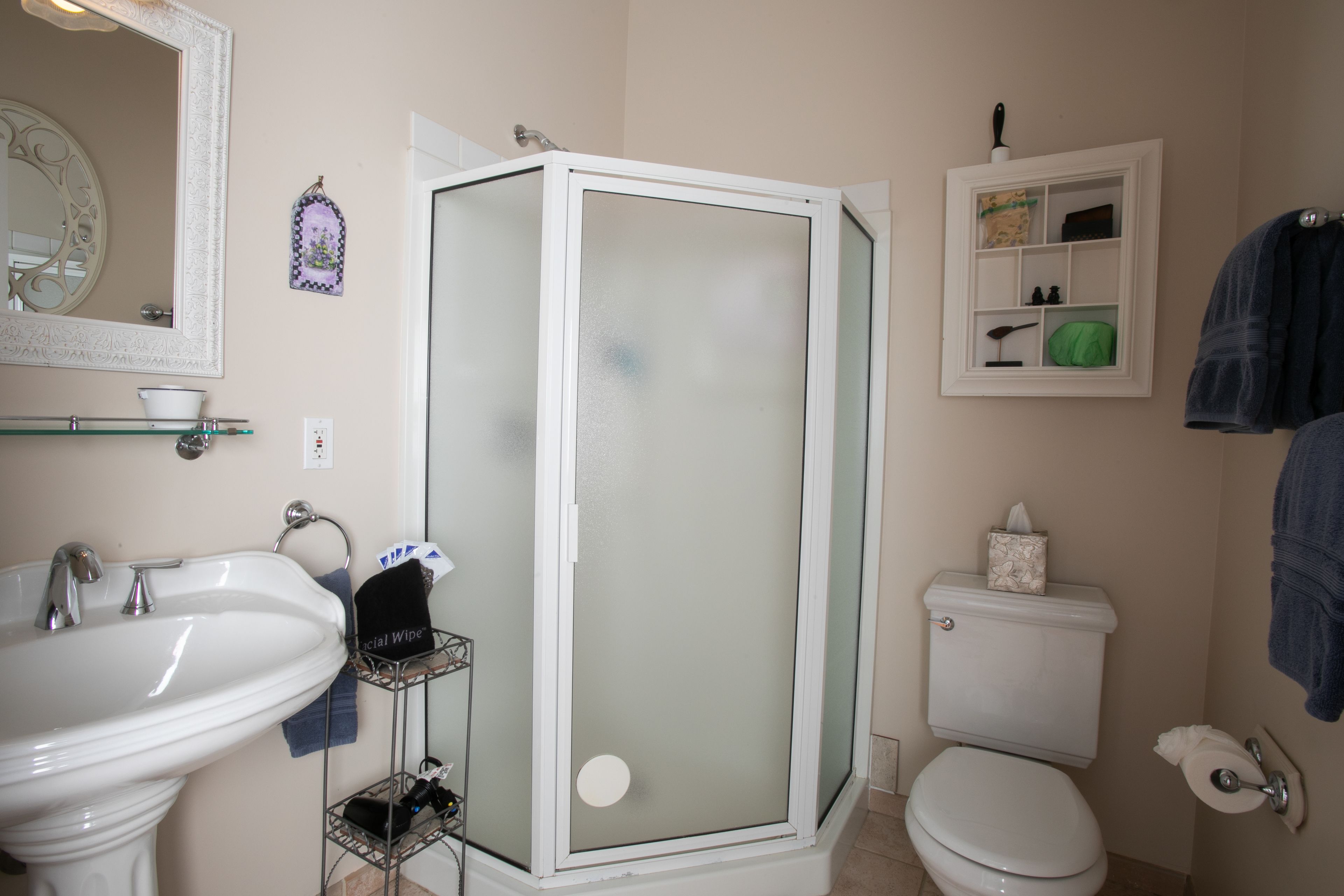 A bathroom with a sink, toilet, and a glass-enclosed shower.