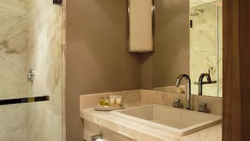 Un baño moderno con un espejo grande, dos lavamanos y una zona de ducha.