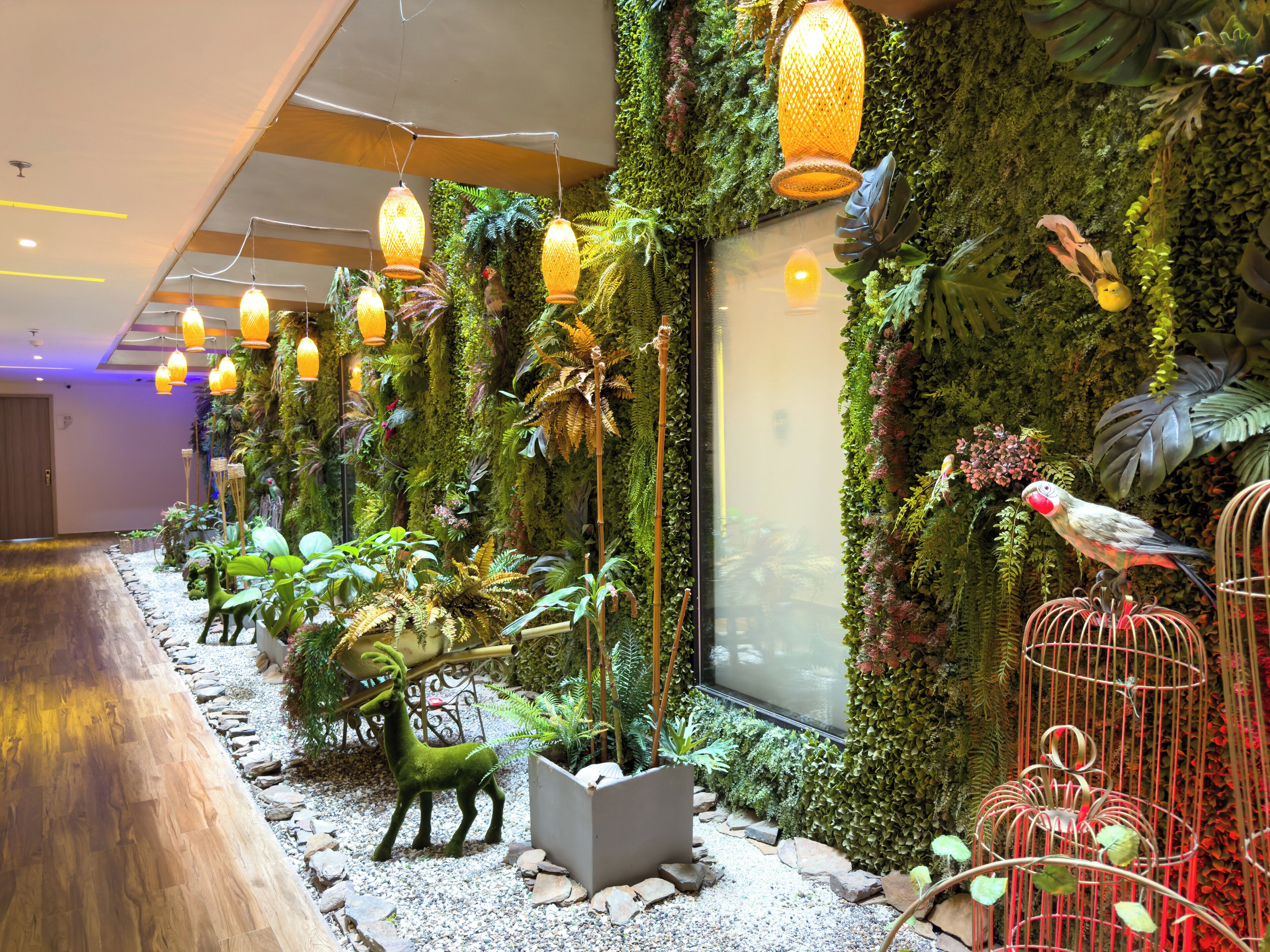 A room with a green wall, a wooden floor, and a birdcage.
