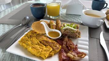 Un plato de desayuno con huevos, tocino y arroz.