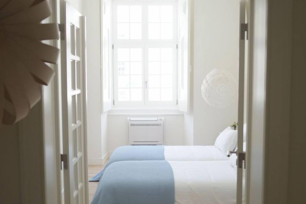 Ein Schlafzimmer mit großem Fenster, einem Bett und einer Heizung.