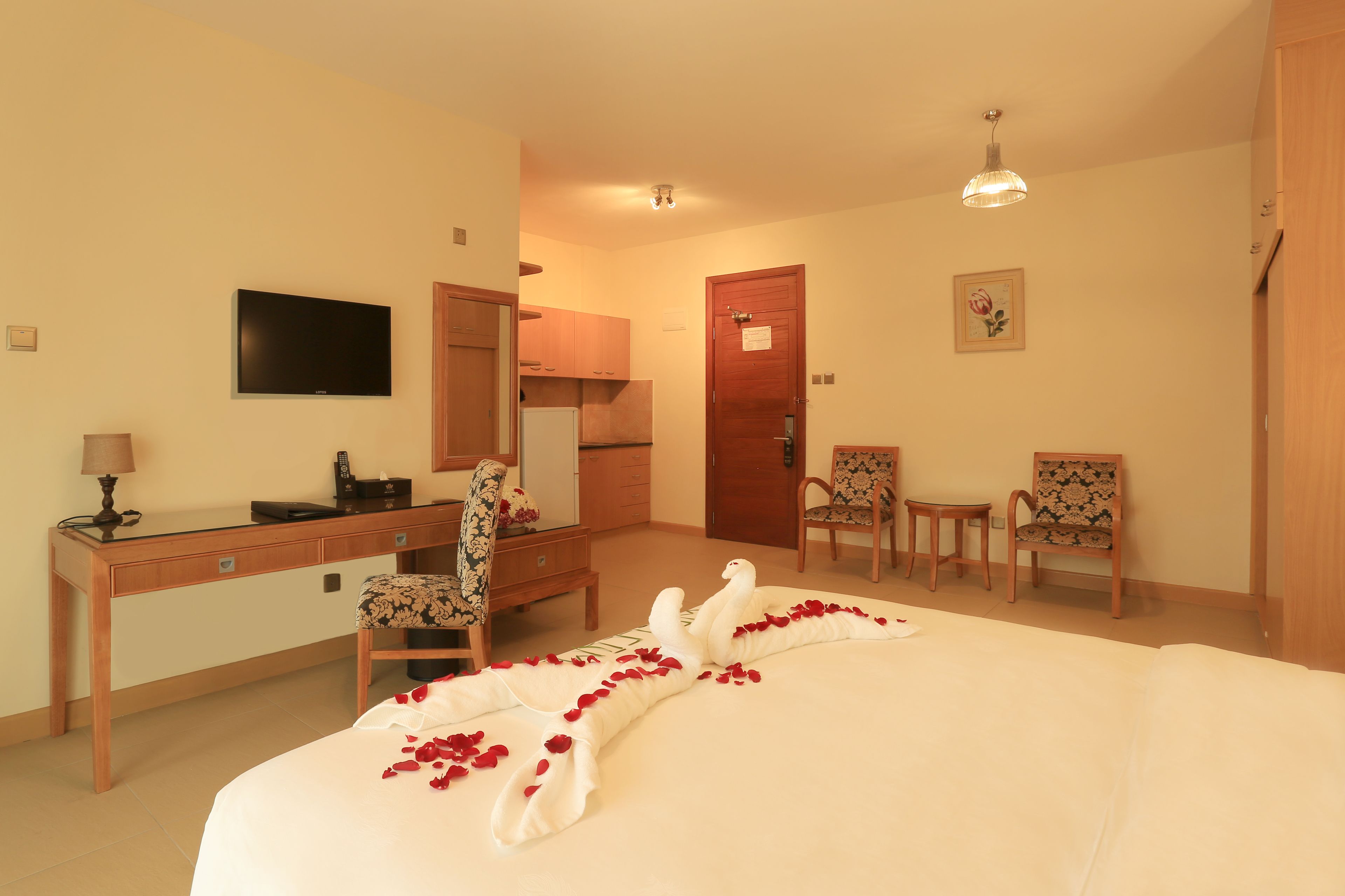 A hotel room with a bed, a desk, a television, a chair, and a small table.