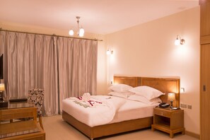 Enjoy a restful stay in this inviting room with a comfortable bed, bedside table, and large window.