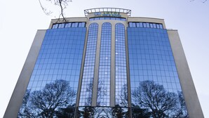 A high-rise building with a reflective glass facade, a prominent entrance with a canopy, and a visible tree in the foreground. - Lotos Inn & Suites, Nairobi (Nairobi)