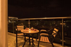 Enjoy dining al fresco with a round table set for four, overlooking the city skyline.