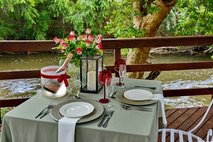 Una mesa para dos con vista a un río y follaje.