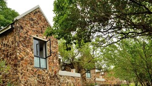 A stone building with a window and a pathway leading to it. - Thanda Manzi Country Hotel (Centurion)