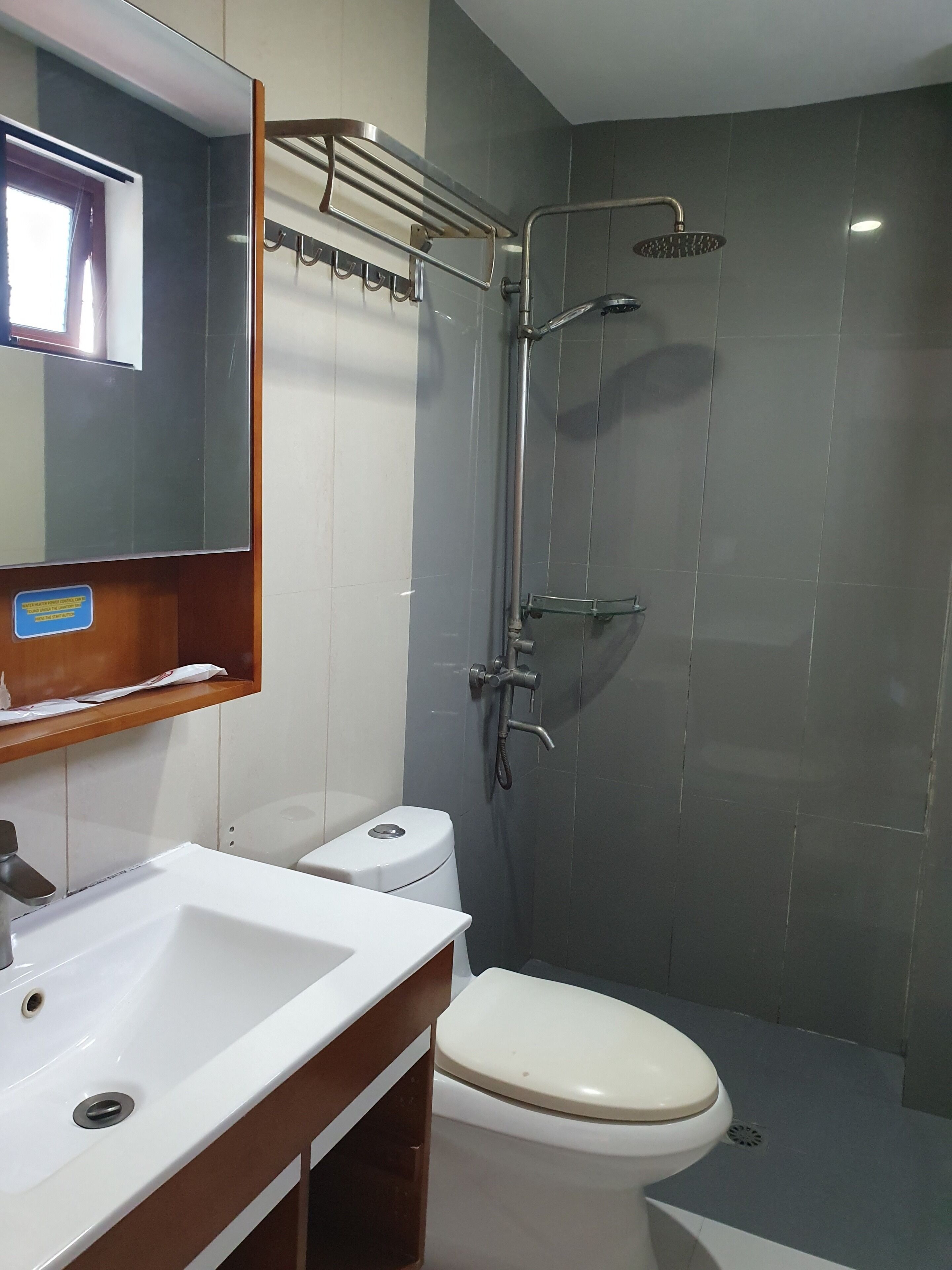 Ein modernes Badezimmer mit Waschbecken, Toilette und Dusche, alles in Weiß.