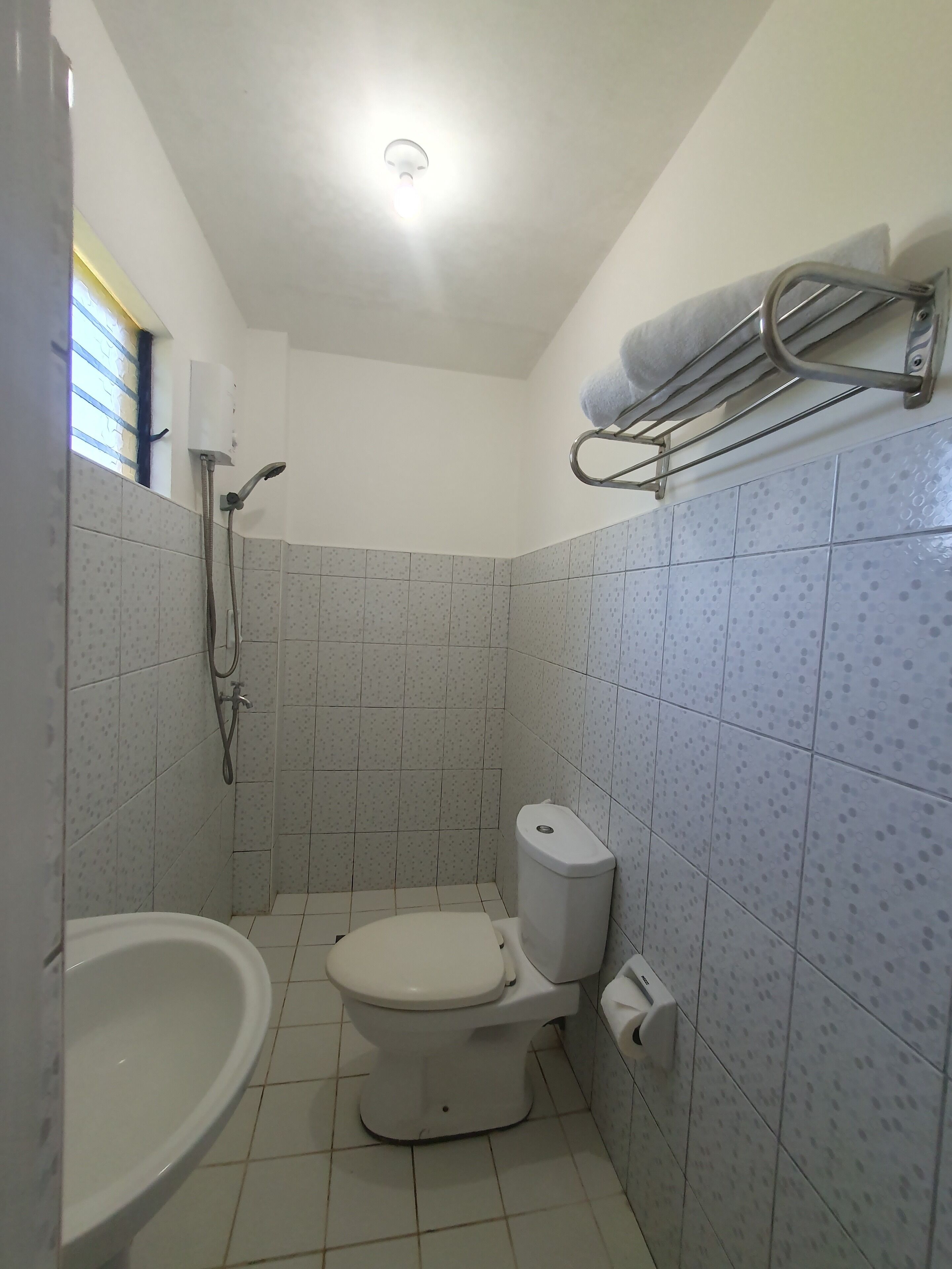 Ein kleines Badezimmer mit Toilette, Waschbecken und Dusche.