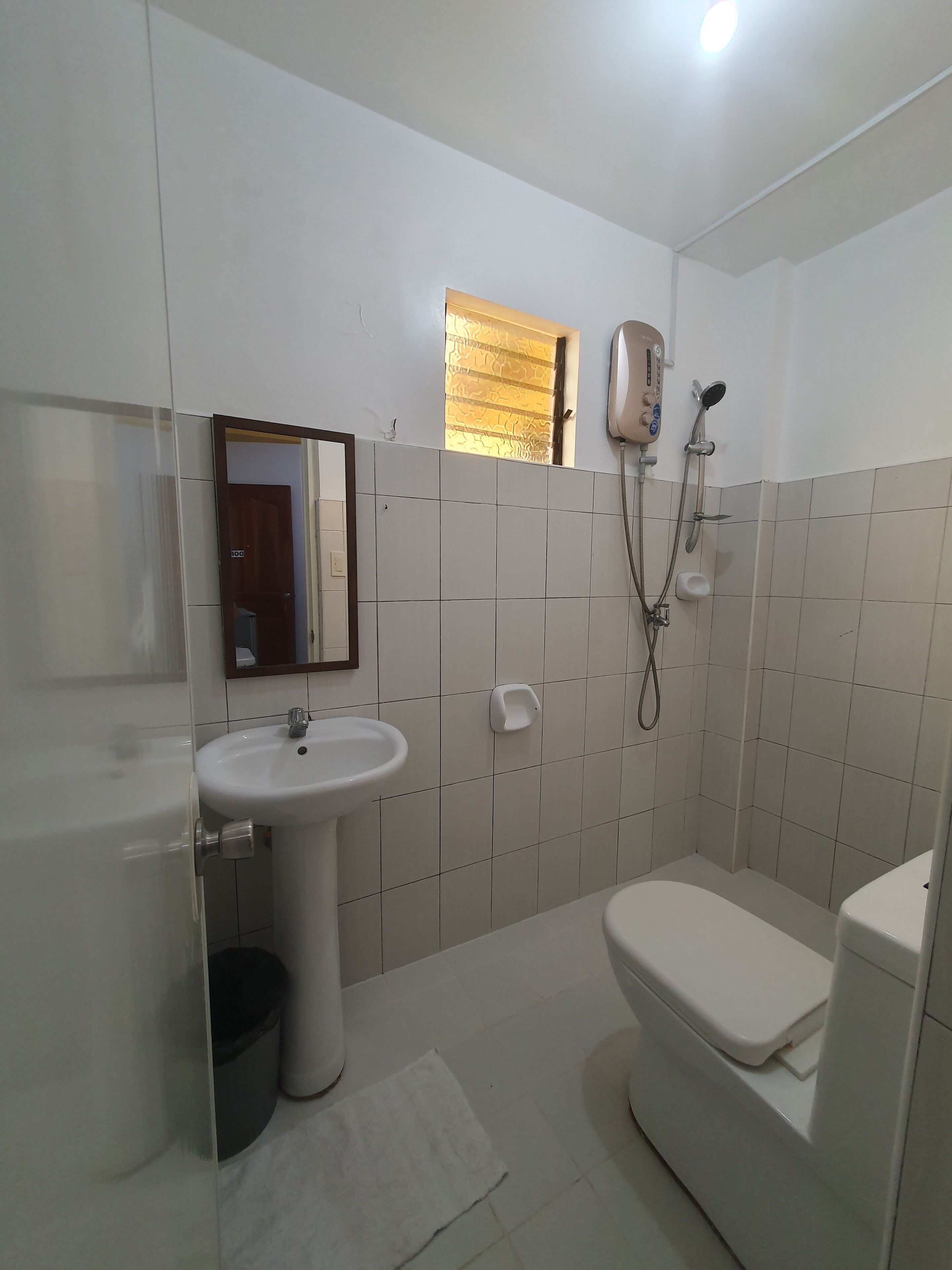 A bathroom with a toilet, sink, and shower.