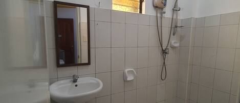 A bathroom with a toilet, sink, and shower.