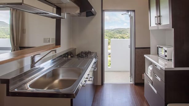 Una cocina moderna con electrodomésticos de acero inoxidable, un fregadero amplio y vistas al exterior.