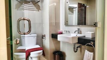 Un baño moderno con inodoro, lavamanos, espejo y bidé.