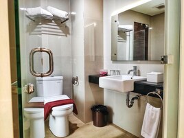 Un baño moderno con inodoro, lavamanos, espejo y bidé.