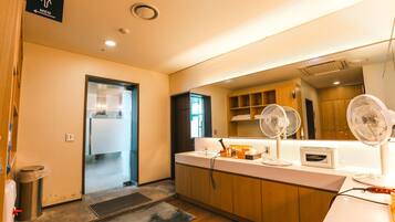 A modern bathroom with a sink, mirror, and two wall-mounted fans.