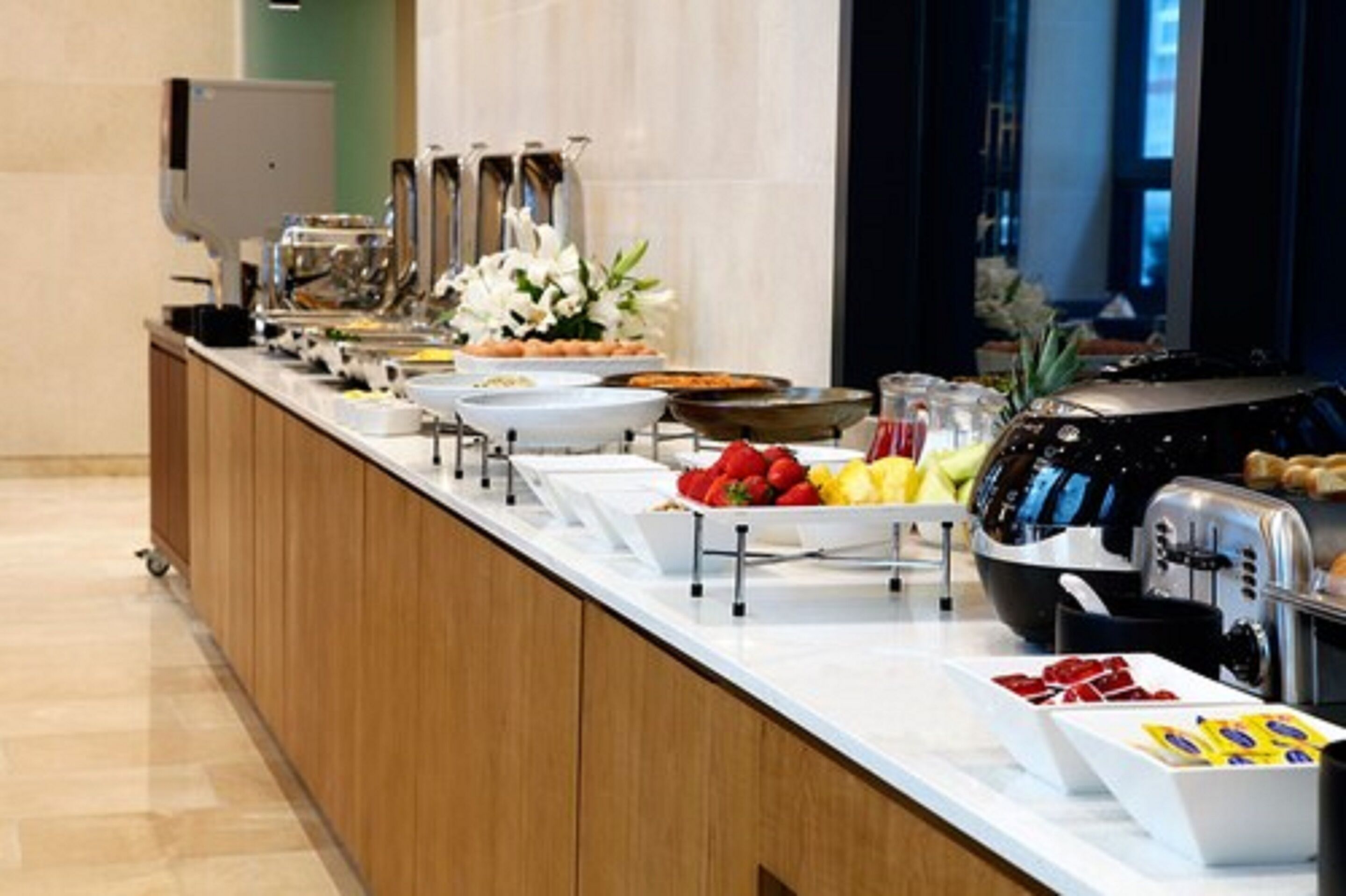 A buffet setup with various food items and a toaster.
