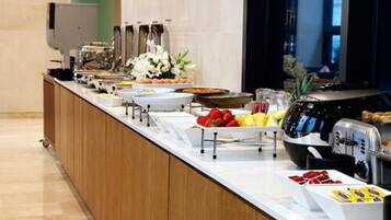 A buffet setup with various food items and a toaster.
