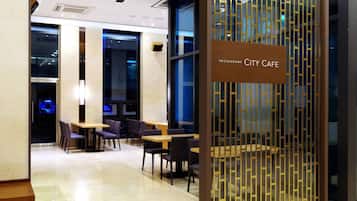 Ein modernes Restaurant-Interieur, mit einem Schild, auf dem 'RESTAURANT CITY CAFE' steht.