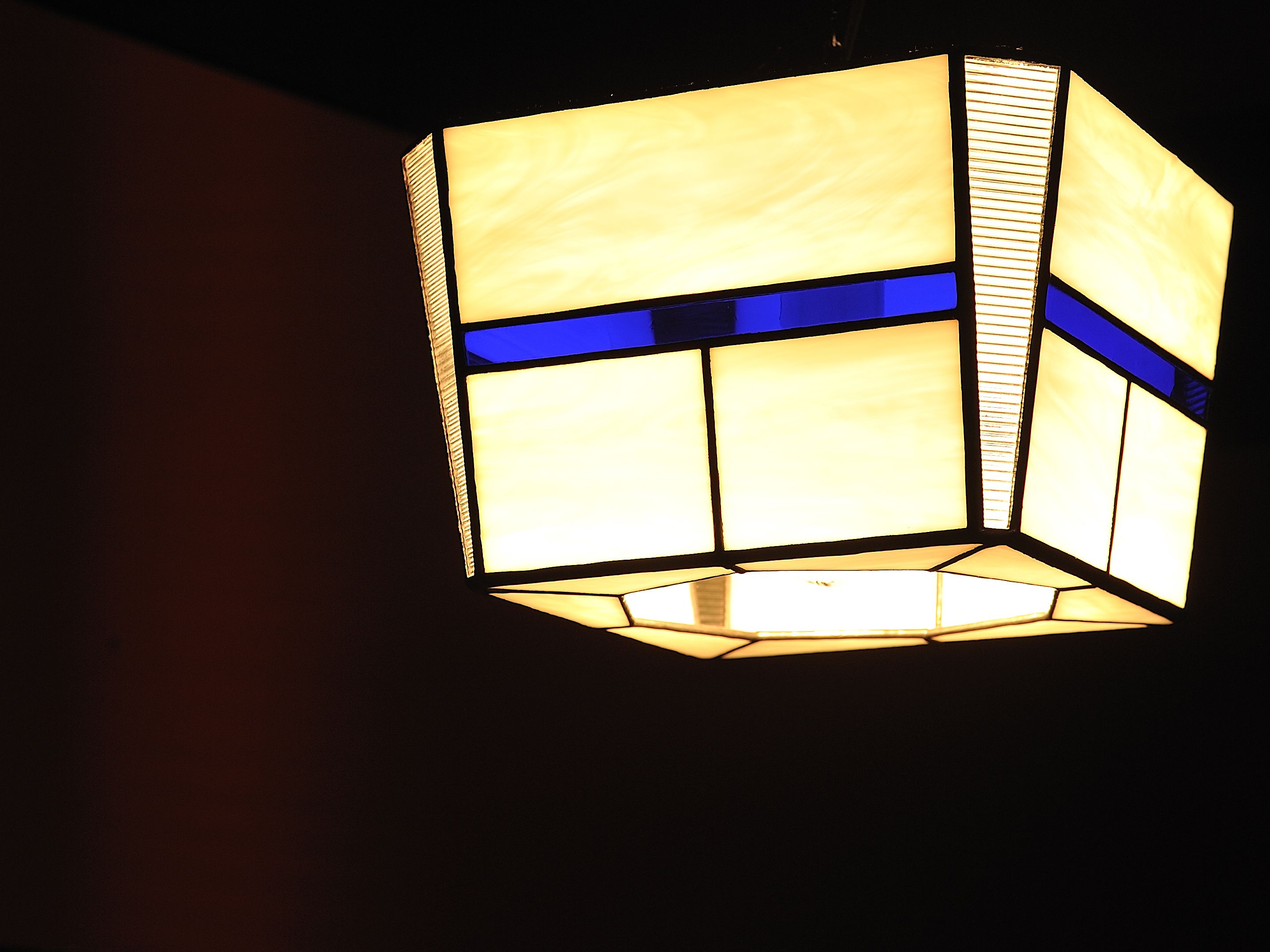 Een hanglamp met een geometrisch ontwerp en een blauwe accentkleur.