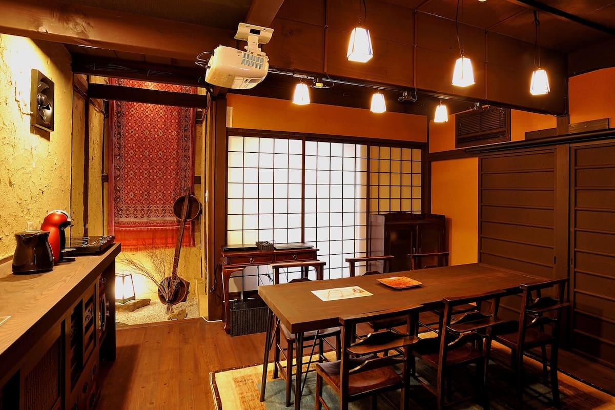 Une pièce de style japonais traditionnel, avec un sol recouvert de tatamis, une petite table en bois et une porte coulissante.