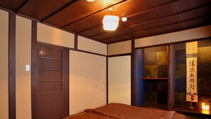 A traditional Japanese-style room with tatami flooring, a sliding door, and a window with a view of the outside. - Theatre and Library Residence -Kyoto Imagumano- (Kyoto)