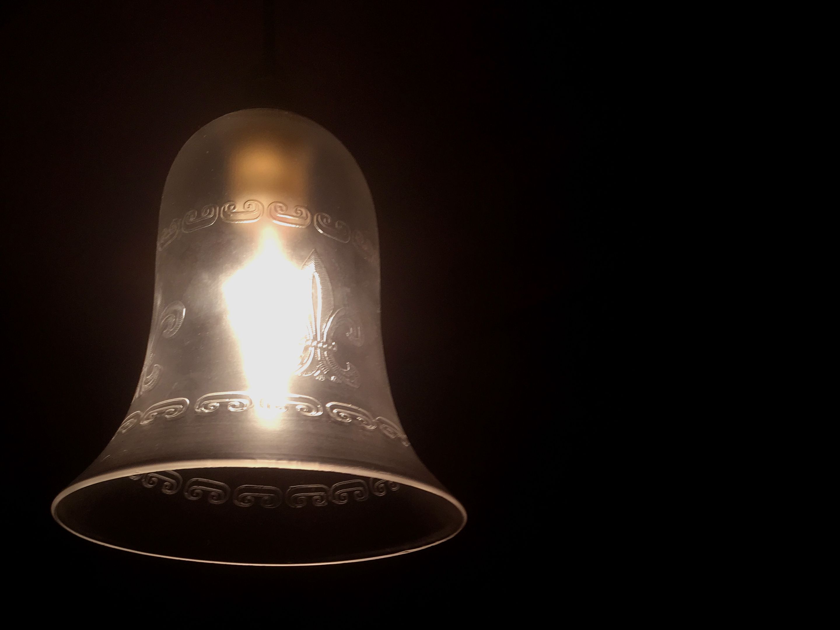A metallic bell with embossed designs.