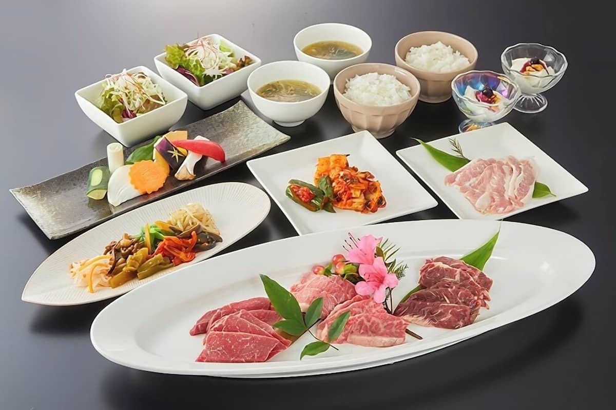Diversos plats, com sushi, arròs i verdures, presentats sobre una taula.