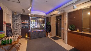 A hotel lobby with a reception desk, a small kiosk with various items, and an elevator. - Hotel Saint Martin – Adults Only (Kyoto)