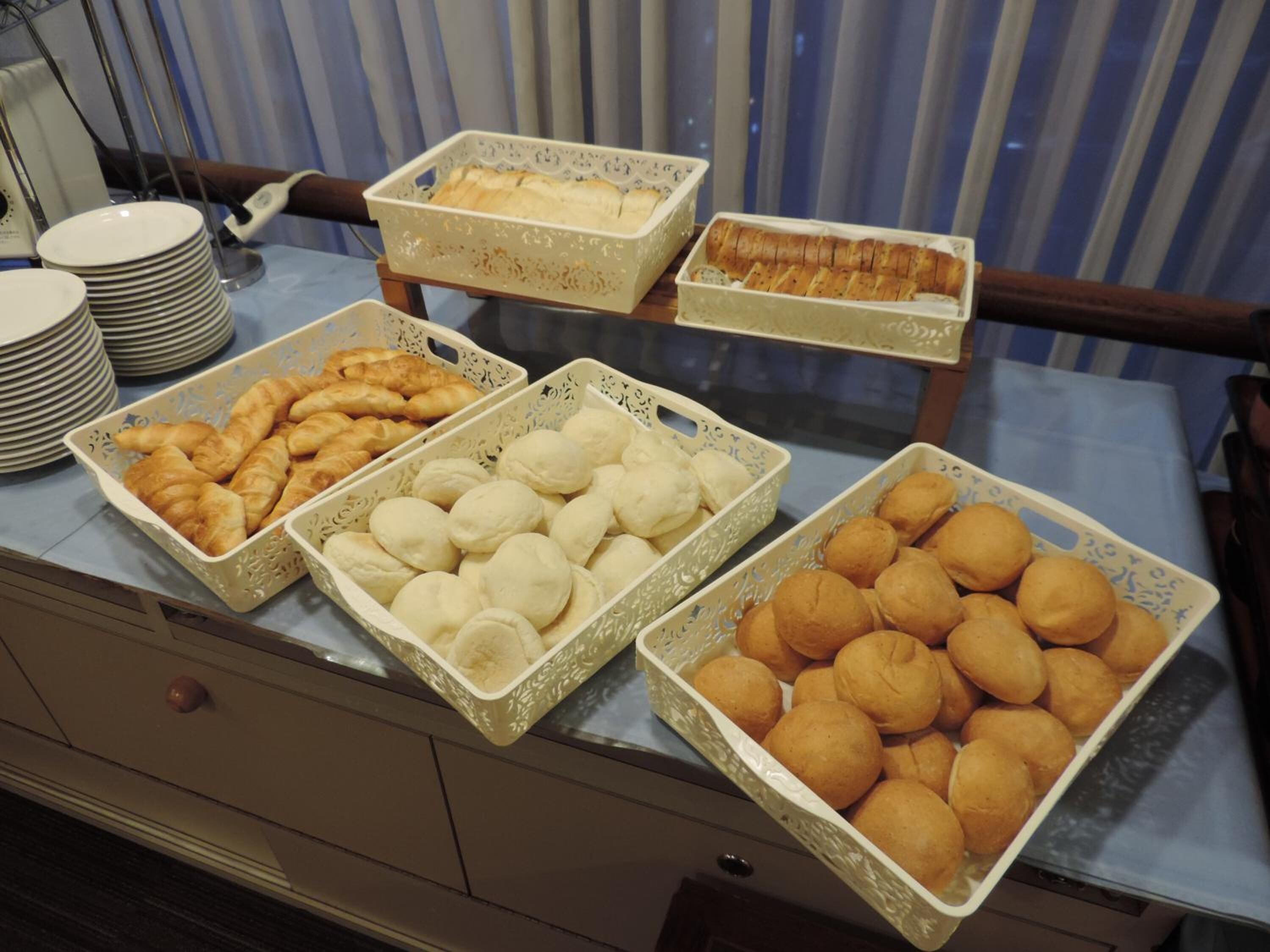 Ein Buffet mit verschiedenen Backwaren, darunter Croissants, Brötchen und Gebäck.