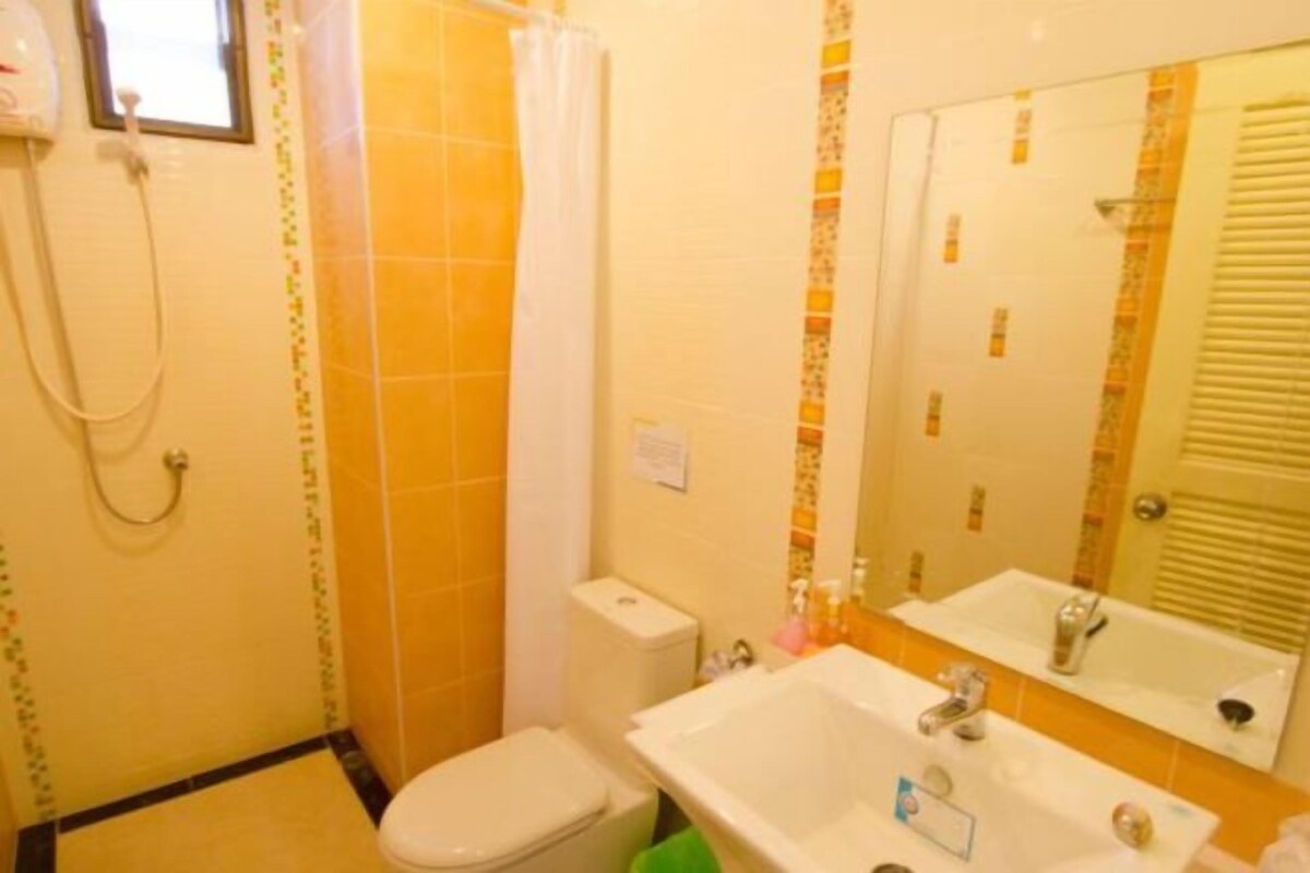 Un baño pequeño con inodoro, lavamanos y ducha.