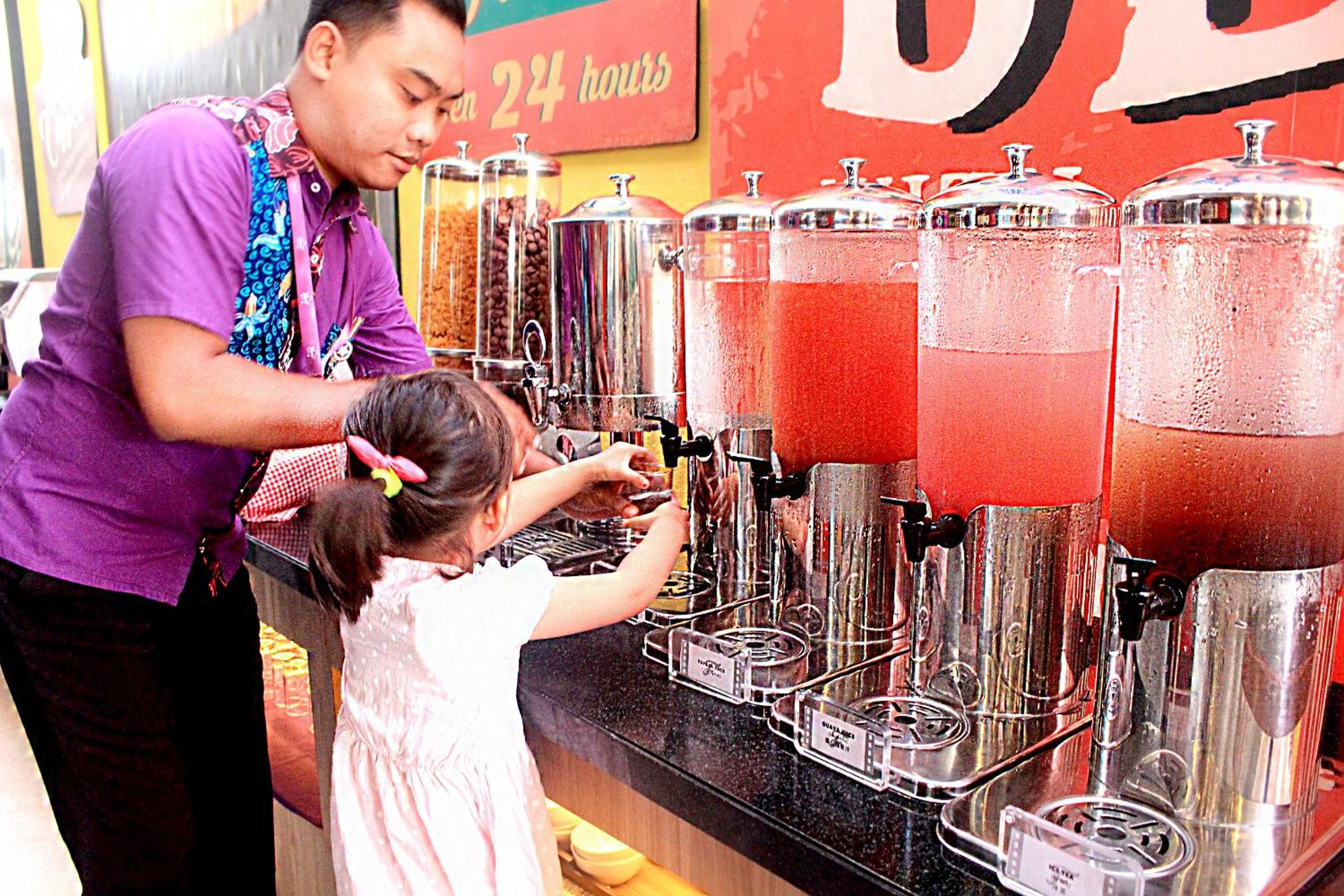 Una persona preparando una bebida en un dispensador con varios recipientes.