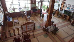 A spacious lobby with a high ceiling, large windows, and a variety of seating areas. - Champa Hotel (Pakse)