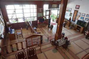 A spacious lobby with a high ceiling, large windows, and a variety of seating areas.
