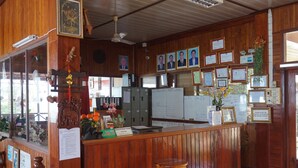 A reception desk with framed certificates, a whiteboard, and a wooden interior. - Mekong Paradise Resort (Pakse)