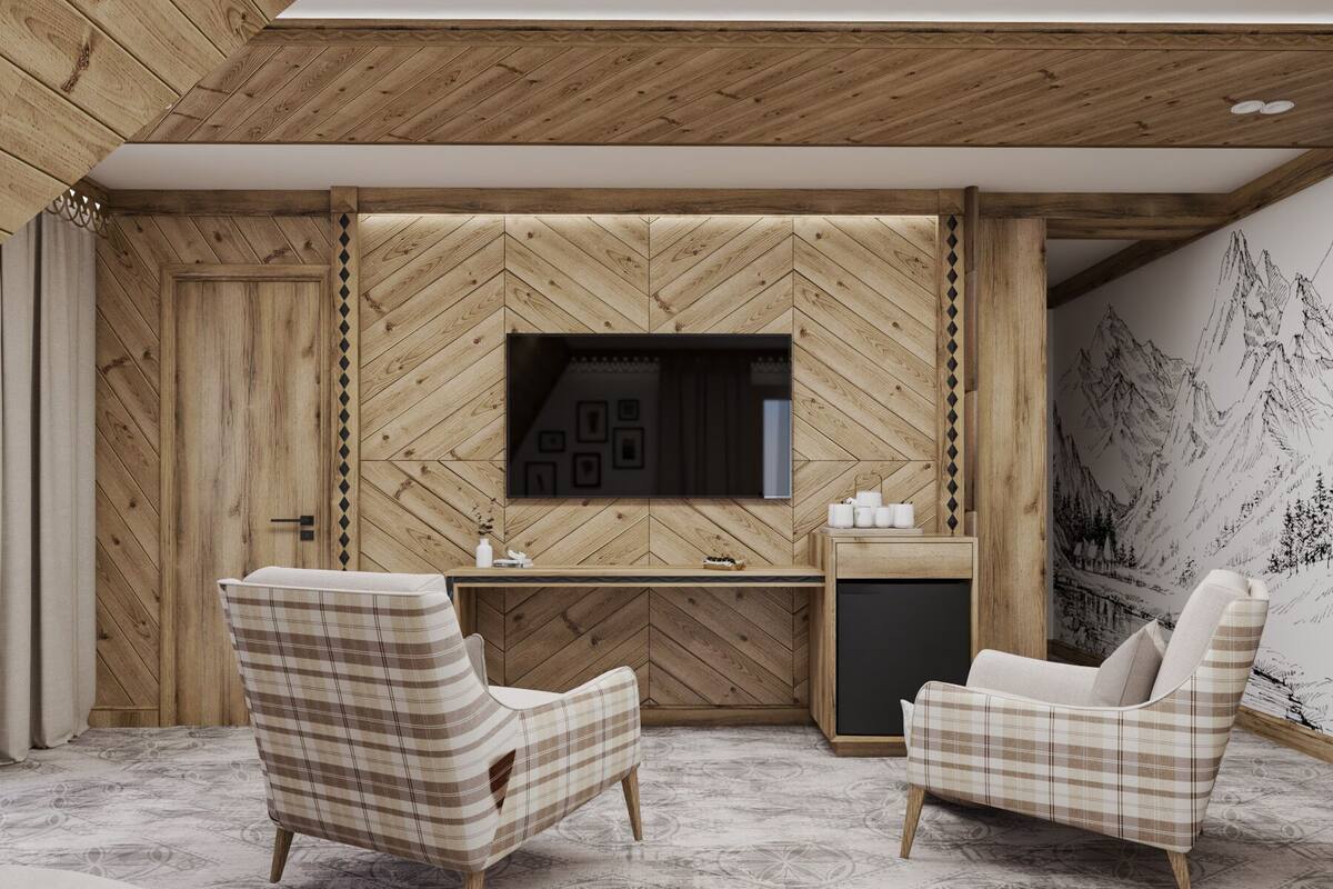 A modern living room with a herringbone-patterned wooden wall, a flat-screen TV, two plaid armchairs, a small side table, and a decorative wall mural.