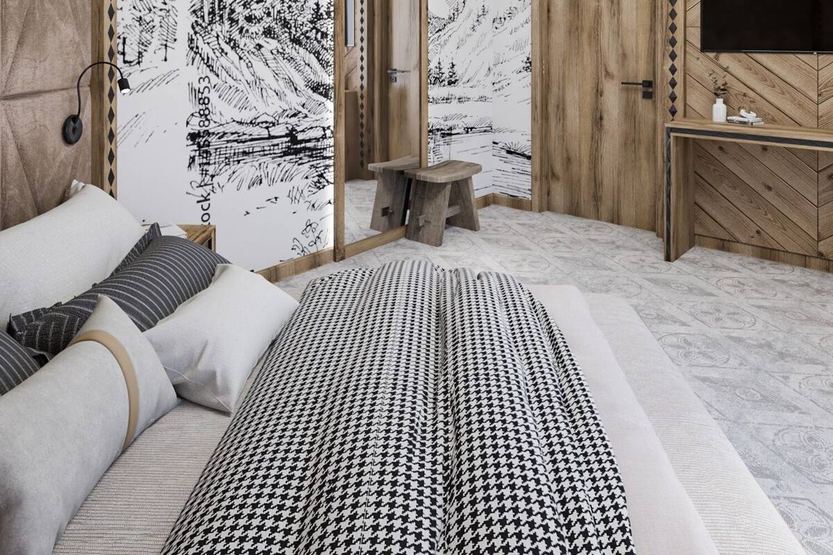 A modern bedroom with a large bed, a wooden desk, and a TV.