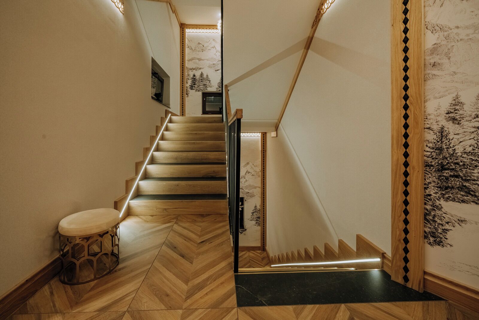 A wooden staircase with a herringbone floor pattern leading to a landing.